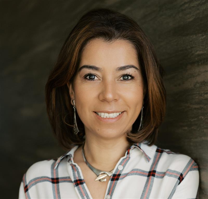 Paola Turchi Light skinned woman with short brown hair wearing a red and white button down
